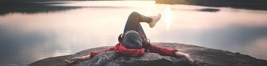 A serene scene of a person meditating outdoors, surrounded by lush greenery, symbolizing mindfulness and calmness.