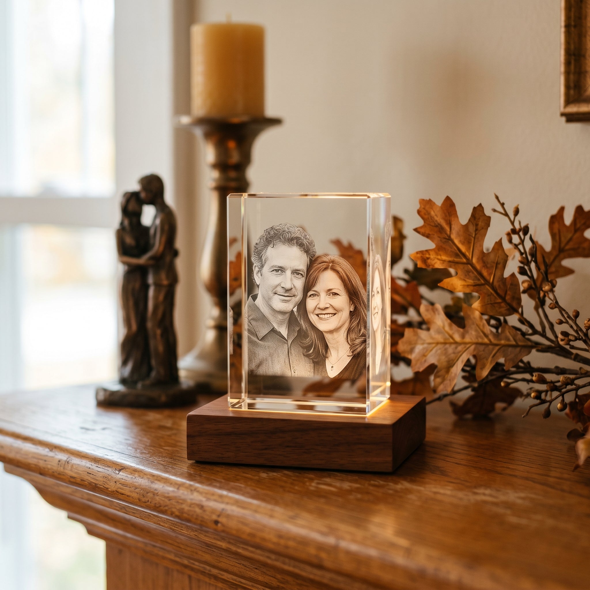 Beyond Memories rectangle 3D photo crystal of a couple, 19-year bronze anniversary on a fall mantelpiece with bronze sculpture and oak leaves in deep bokeh.