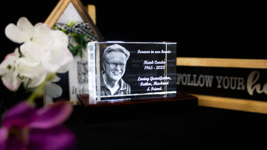 3D engraved crystal of a smiling older man surrounded by home decor, white flowers, and a sign that reads “Follow your heart.”