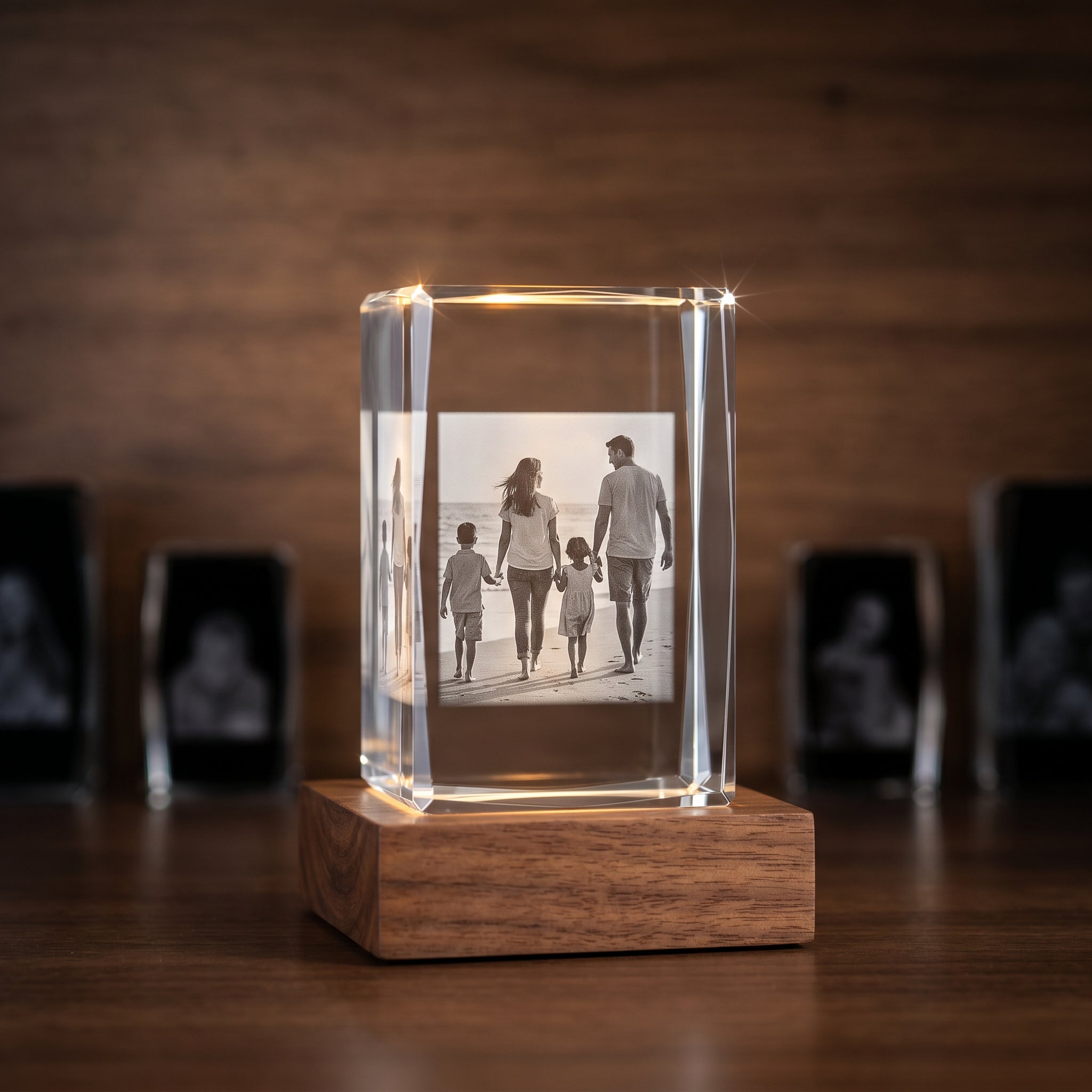Beyond Memories rectangle 3D crystal on rosewood base on a gallery shelf in warm focus with three smaller competitor crystals in muted bokeh on either side.