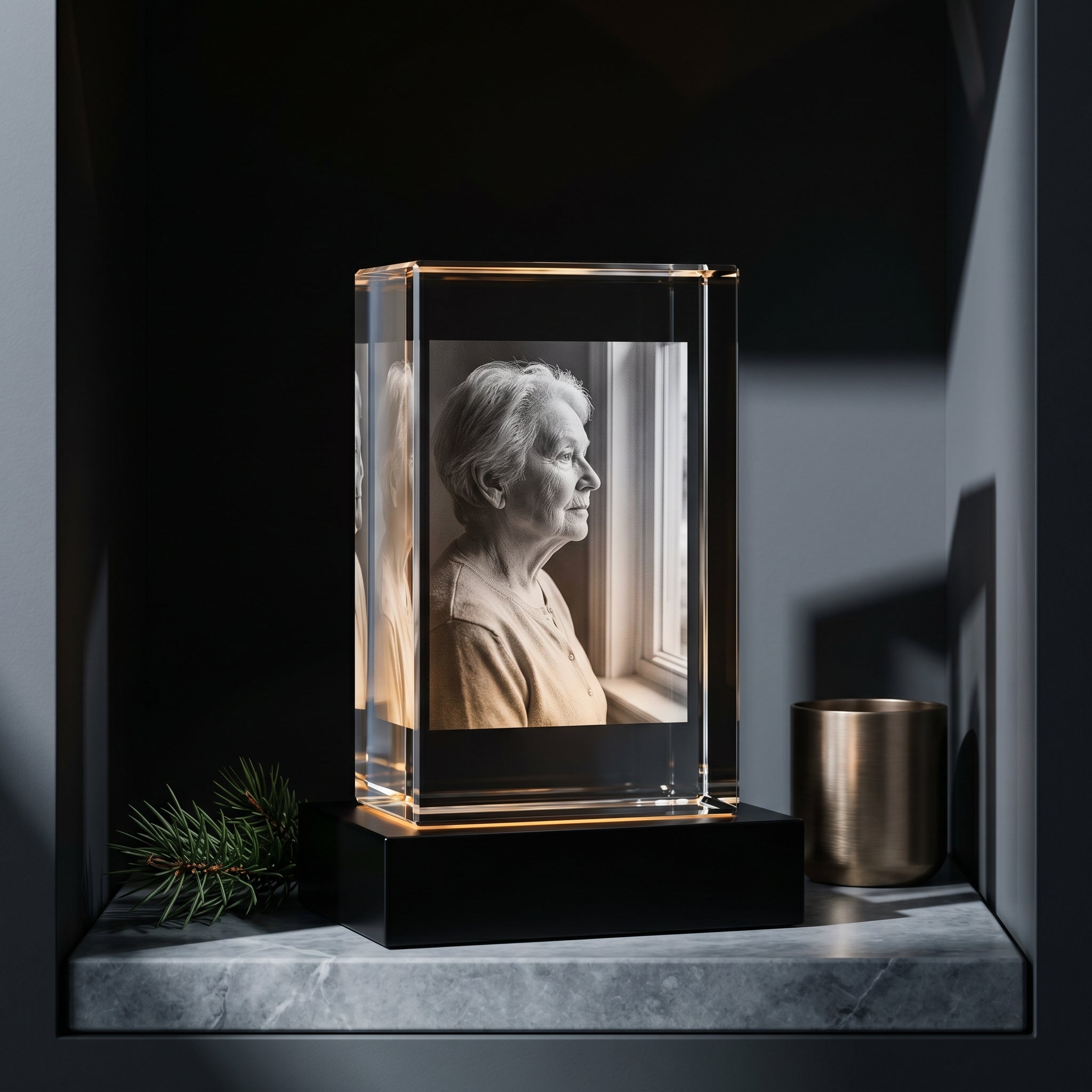 Beyond Memories 3D crystal portrait of elderly woman in profile, black base, marble slab with pine sprig and brass candleholder